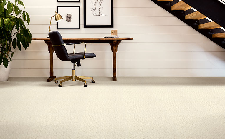 light carpet in basement area with desk area